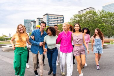 Açık havada kaynaşan neşeli çoklu etnik kökenli genç arkadaş grubu - çok ırklı öğrenciler şehirde buluşuyor, gençlik kavramları, insan yaşam tarzı, çeşitlilik, gençlik ve şehir hayatı