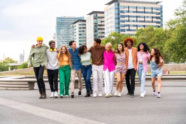 Açık havada kaynaşan neşeli çoklu etnik kökenli genç arkadaş grubu - çok ırklı öğrenciler şehirde buluşuyor, gençlik kavramları, insan yaşam tarzı, çeşitlilik, gençlik ve şehir hayatı