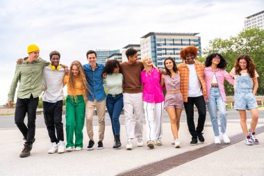 Açık havada kaynaşan neşeli çoklu etnik kökenli genç arkadaş grubu - çok ırklı öğrenciler şehirde buluşuyor, gençlik kavramları, insan yaşam tarzı, çeşitlilik, gençlik ve şehir hayatı