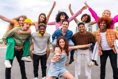 Açık havada kaynaşan neşeli çoklu etnik kökenli genç arkadaş grubu - çok ırklı öğrenciler şehirde buluşuyor, gençlik kavramları, insan yaşam tarzı, çeşitlilik, gençlik ve şehir hayatı