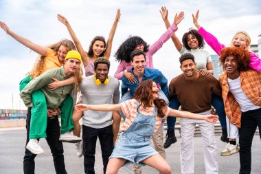 Açık havada kaynaşan neşeli çoklu etnik kökenli genç arkadaş grubu - çok ırklı öğrenciler şehirde buluşuyor, gençlik kavramları, insan yaşam tarzı, çeşitlilik, gençlik ve şehir hayatı