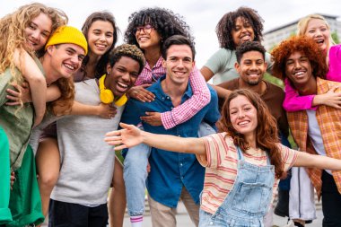 Açık havada kaynaşan neşeli çoklu etnik kökenli genç arkadaş grubu - çok ırklı öğrenciler şehirde buluşuyor, gençlik kavramları, insan yaşam tarzı, çeşitlilik, gençlik ve şehir hayatı
