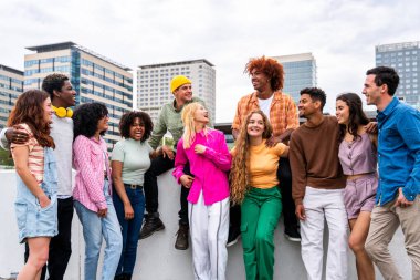 Açık havada kaynaşan neşeli çoklu etnik kökenli genç arkadaş grubu - çok ırklı öğrenciler şehirde buluşuyor, gençlik kavramları, insan yaşam tarzı, çeşitlilik, gençlik ve şehir hayatı