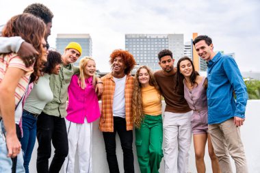 Açık havada kaynaşan neşeli çoklu etnik kökenli genç arkadaş grubu - çok ırklı öğrenciler şehirde buluşuyor, gençlik kavramları, insan yaşam tarzı, çeşitlilik, gençlik ve şehir hayatı