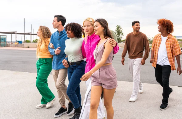 stock image Happy playful multiethnic group of young friends bonding outdoors - Multiracial millennials students meeting in the city, concepts of youth, people lifestyle, diversity, teenage and urban life