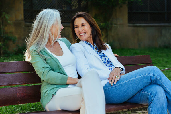 Beautiful senior women bonding outdoors in the city - Attractive cheerful mature female friends having fun, shopping and bonding, concepts about elderly lifestyle