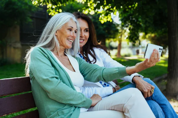 stock image Beautiful senior women bonding outdoors in the city - Attractive cheerful mature female friends having fun, shopping and bonding, concepts about elderly lifestyle