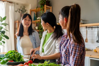 Mutlu Çinli kadın arkadaşlar evde kaynaşıyor ve birlikte lezzetli yemekler pişiriyorlar eğlenceli Asyalı kadın yetişkinler buluşuyor ve evde eğleniyorlar, yaşam tarzı, ev hayatı ve arkadaşlık kavramları.