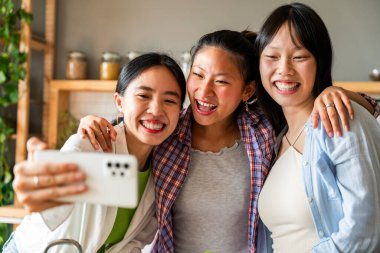 Mutlu güzel Çinli kadın arkadaşlar evde kaynaşıyor, eğlenceli Asyalı kadın yetişkinler buluşuyor ve evde eğleniyorlar, yaşam tarzı, aile hayatı ve arkadaşlık kavramları