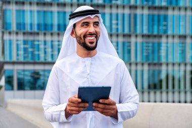 Arap Ortadoğu 'lu, Emirati Kandora giysili, şehirde geleneksel giysiler giyen Arap Müslüman iş adamı, şehir iş merkezinde geziniyor..