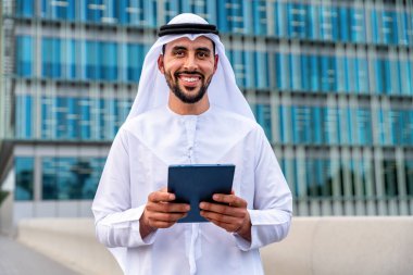 Arap Ortadoğu 'lu, Emirati Kandora giysili, şehirde geleneksel giysiler giyen Arap Müslüman iş adamı, şehir iş merkezinde geziniyor..