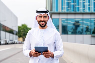 Arap Ortadoğu 'lu, Emirati Kandora giysili, şehirde geleneksel giysiler giyen Arap Müslüman iş adamı, şehir iş merkezinde geziniyor..