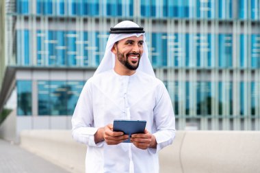 Arap Ortadoğu 'lu, Emirati Kandora giysili, şehirde geleneksel giysiler giyen Arap Müslüman iş adamı, şehir iş merkezinde geziniyor..