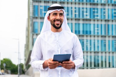 Arap Ortadoğu 'lu, Emirati Kandora giysili, şehirde geleneksel giysiler giyen Arap Müslüman iş adamı, şehir iş merkezinde geziniyor..