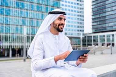 Arap Ortadoğu 'lu, Emirati Kandora giysili, şehirde geleneksel giysiler giyen Arap Müslüman iş adamı, şehir iş merkezinde geziniyor..