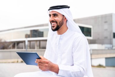 Arap Ortadoğu 'lu, Emirati Kandora giysili, şehirde geleneksel giysiler giyen Arap Müslüman iş adamı, şehir iş merkezinde geziniyor..