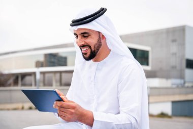 Arap Ortadoğu 'lu, Emirati Kandora giysili, şehirde geleneksel giysiler giyen Arap Müslüman iş adamı, şehir iş merkezinde geziniyor..