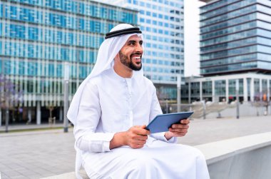 Arap Ortadoğu 'lu, Emirati Kandora giysili, şehirde geleneksel giysiler giyen Arap Müslüman iş adamı, şehir iş merkezinde geziniyor..