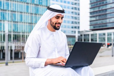 Arap Ortadoğu 'lu, Emirati Kandora giysili, şehirde geleneksel giysiler giyen Arap Müslüman iş adamı, şehir iş merkezinde geziniyor..