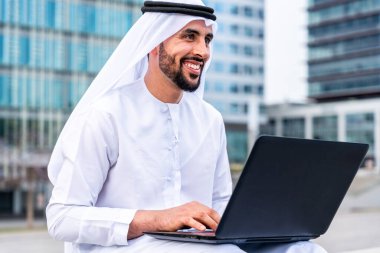 Arap Ortadoğu 'lu, Emirati Kandora giysili, şehirde geleneksel giysiler giyen Arap Müslüman iş adamı, şehir iş merkezinde geziniyor..