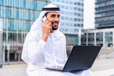 Arap Ortadoğu 'lu, Emirati Kandora giysili, şehirde geleneksel giysiler giyen Arap Müslüman iş adamı, şehir iş merkezinde geziniyor..