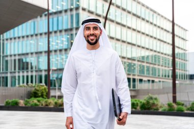 Arap Ortadoğu 'lu, Emirati Kandora giysili, şehirde geleneksel giysiler giyen Arap Müslüman iş adamı, şehir iş merkezinde geziniyor..
