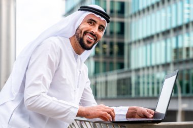 Arap Ortadoğu 'lu, Emirati Kandora giysili, şehirde geleneksel giysiler giyen Arap Müslüman iş adamı, şehir iş merkezinde geziniyor..