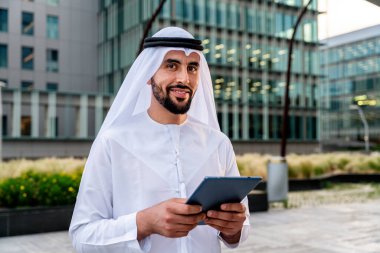 Arap Ortadoğu 'lu, Emirati Kandora giysili, şehirde geleneksel giysiler giyen Arap Müslüman iş adamı, şehir iş merkezinde geziniyor..