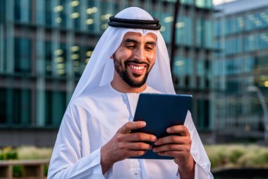 Arap Ortadoğu 'lu, Emirati Kandora giysili, şehirde geleneksel giysiler giyen Arap Müslüman iş adamı, şehir iş merkezinde geziniyor..