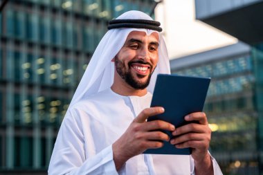 Arap Ortadoğu 'lu, Emirati Kandora giysili, şehirde geleneksel giysiler giyen Arap Müslüman iş adamı, şehir iş merkezinde geziniyor..