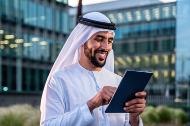 Arap Ortadoğu 'lu, Emirati Kandora giysili, şehirde geleneksel giysiler giyen Arap Müslüman iş adamı, şehir iş merkezinde geziniyor..