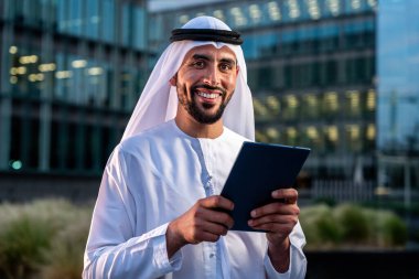 Arap Ortadoğu 'lu, Emirati Kandora giysili, şehirde geleneksel giysiler giyen Arap Müslüman iş adamı, şehir iş merkezinde geziniyor..