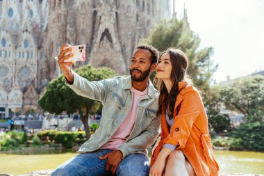 Sagrada Familia, Barcelona 'da buluşan çok ırklı mutlu çift Avrupa' da seyahat eden ve İspanya 'da bir şehri ziyaret eden çok ırklı turistler, turizm ve insan yaşam tarzı kavramları