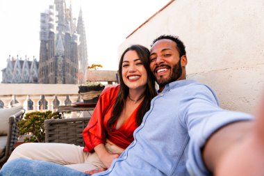 Sagrada Familia, Barcelona 'nın çatı katında buluşan çok ırklı, mutlu aşıklar şehir manzaralı bir terasta romantik bir buluşma, turizm ve insan yaşam tarzı hakkında kavramlar