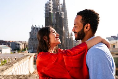 Sagrada Familia, Barcelona 'nın çatı katında buluşan çok ırklı, mutlu aşıklar şehir manzaralı bir terasta romantik bir buluşma, turizm ve insan yaşam tarzı hakkında kavramlar
