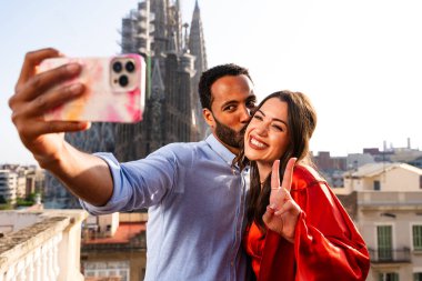 Sagrada Familia, Barcelona 'nın çatı katında buluşan çok ırklı, mutlu aşıklar şehir manzaralı bir terasta romantik bir buluşma, turizm ve insan yaşam tarzı hakkında kavramlar