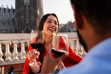 Sagrada Familia, Barcelona 'nın çatı katında buluşan çok ırklı, mutlu aşıklar şehir manzaralı bir terasta romantik aperatifler, turizm ve insan yaşam tarzı hakkında kavramlar