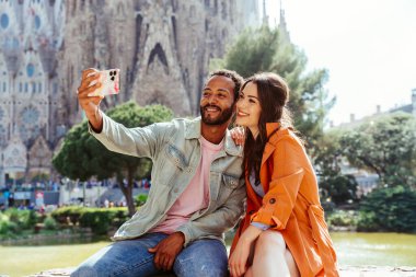 Sagrada Familia, Barcelona 'da buluşan çok ırklı mutlu çift Avrupa' da seyahat eden ve İspanya 'da bir şehri ziyaret eden çok ırklı turistler, turizm ve insan yaşam tarzı kavramları