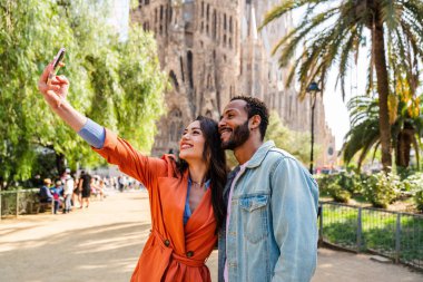 Sagrada Familia, Barcelona 'da buluşan çok ırklı mutlu çift Avrupa' da seyahat eden ve İspanya 'da bir şehri ziyaret eden çok ırklı turistler, turizm ve insan yaşam tarzı kavramları