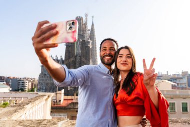 Sagrada Familia, Barcelona 'nın çatı katında buluşan çok ırklı, mutlu aşıklar şehir manzaralı bir terasta romantik bir buluşma, turizm ve insan yaşam tarzı hakkında kavramlar