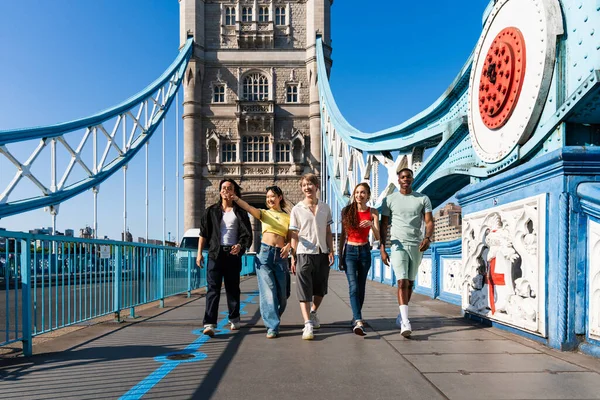 Londra 'da, Tower Bridge bölgesinde buluşup eğlenen çok ırklı genç arkadaş grubu gençlik yaşam tarzı, seyahat ve turizm konseptleri