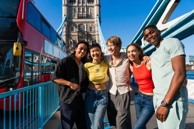 Londra 'da, Tower Bridge bölgesinde buluşup eğlenen çok ırklı genç arkadaş grubu gençlik yaşam tarzı, seyahat ve turizm konseptleri