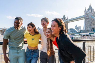 Londra 'da, Tower Bridge bölgesinde buluşup eğlenen çok ırklı genç arkadaş grubu gençlik yaşam tarzı, seyahat ve turizm konseptleri