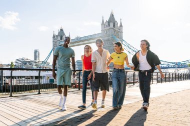 Londra 'da, Tower Bridge bölgesinde buluşup eğlenen çok ırklı genç arkadaş grubu gençlik yaşam tarzı, seyahat ve turizm konseptleri