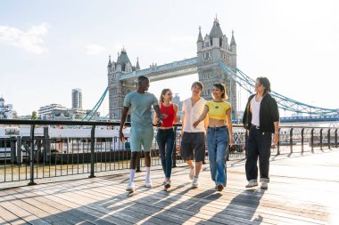 Londra 'da, Tower Bridge bölgesinde buluşup eğlenen çok ırklı genç arkadaş grubu gençlik yaşam tarzı, seyahat ve turizm konseptleri