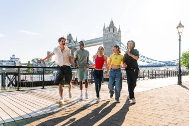 Londra 'da, Tower Bridge bölgesinde buluşup eğlenen çok ırklı genç arkadaş grubu gençlik yaşam tarzı, seyahat ve turizm konseptleri