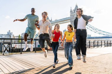 Londra 'da, Tower Bridge bölgesinde buluşup eğlenen çok ırklı genç arkadaş grubu gençlik yaşam tarzı, seyahat ve turizm konseptleri