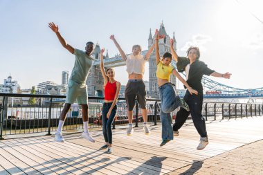 Londra 'da, Tower Bridge bölgesinde buluşup eğlenen çok ırklı genç arkadaş grubu gençlik yaşam tarzı, seyahat ve turizm konseptleri