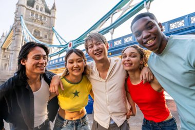 Londra 'da, Tower Bridge bölgesinde buluşup eğlenen çok ırklı genç arkadaş grubu gençlik yaşam tarzı, seyahat ve turizm konseptleri