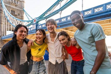 Londra 'da, Tower Bridge bölgesinde buluşup eğlenen çok ırklı genç arkadaş grubu gençlik yaşam tarzı, seyahat ve turizm konseptleri